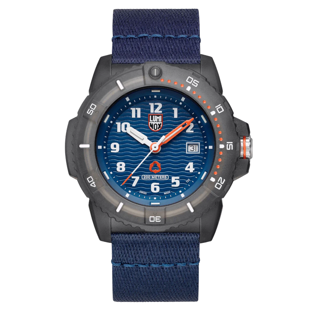 A Luminox watch with a blue dial, gray case, and orange details on the bezel and strap, featuring a textured wave pattern on the dial.