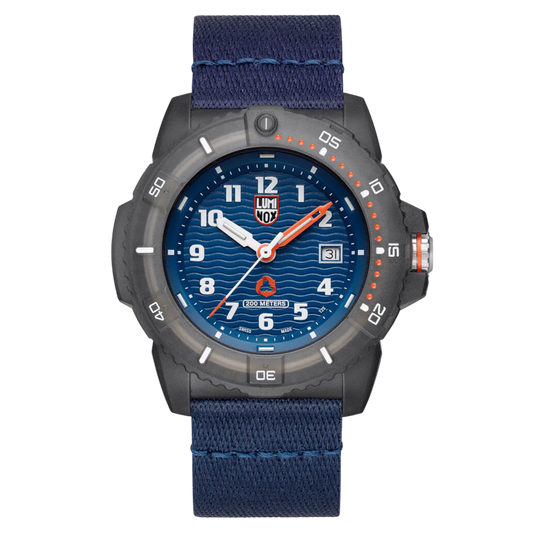 A Luminox watch with a blue dial, gray case, and orange details on the bezel and strap, featuring a textured wave pattern on the dial.
