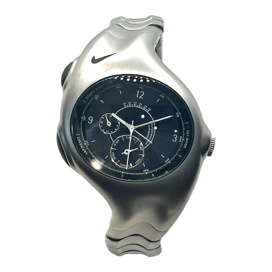 A Nike Triax Armored Quartz Chronograph watch with a stainless steel case and a black dial featuring Arabic numerals and a steel deployment fold clasp.